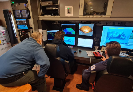 Crew of HMNZS Manawanui review underwater footage of a plane staged on the seabed during the recovery exercise.
