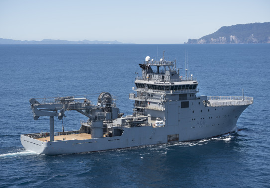 Aerial image of HMNZS Manawanui at sea in the Hauraki Gulf in clear and calm conditions.