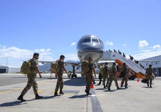 Personnel cross the tarmac in front of the RNZAF Boeing 757 and enter via the side stairs in Fiji, on route to Papua New Guinea.