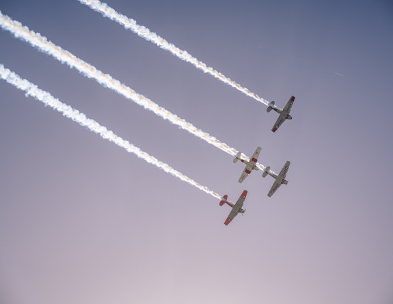 Four aircraft fly in formation high in the sky.